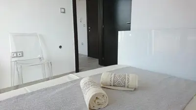 a towel sitting on a bed in front of a mirror at Park Apartments & Rooms Popovi in Sandanski