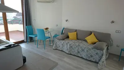 a living room with a couch and a table with chairs at Park Apartments & Rooms Popovi in Sandanski