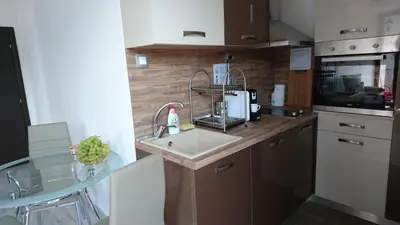 a kitchen with a sink and a glass table at Park Apartments & Rooms Popovi in Sandanski