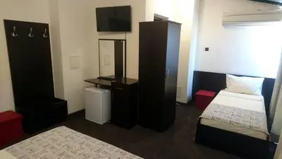 a room with a bedroom with a bed and a mirror at Park Apartments & Rooms Popovi in Sandanski