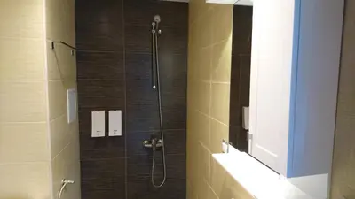 a bathroom with a shower with a glass door at Park Apartments & Rooms Popovi in Sandanski