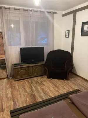 a living room with a chair and a flat screen tv at Hot Spot Studio in the center in Sofia