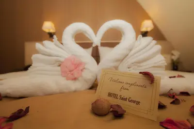 two swans made out of towels on a bed with a sign at Family Hotel Saint George in Sofia