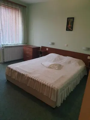 a bedroom with a bed and a desk and a window at Guesthouse Kiritsovi in Bansko