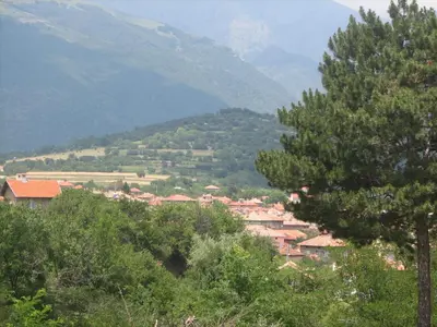 a town in a valley with mountains in the background at Family Hotel Kalifer in Kalofer