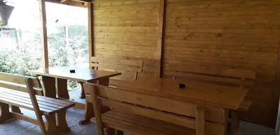 two wooden tables and benches in a room with a window at Guest House Ideal in Sapareva Banya