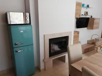 a blue refrigerator in a living room with a fireplace at Grand Monastery - Azure Apartment in Pamporovo
