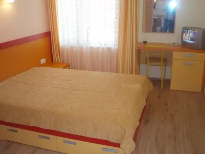 a bedroom with a bed and a table and a desk at Mania Guest House in Kalofer