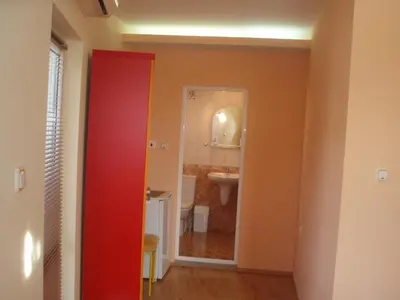 a bathroom with a red door and a sink at Mania Guest House in Kalofer
