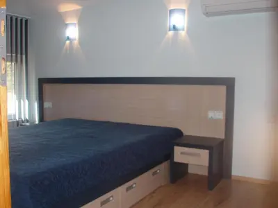 a bedroom with a bed and two lights on the wall at Mania Guest House in Kalofer