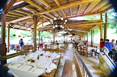 a restaurant with white tables and people sitting at tables at Family Hotel Gorski Kut in Rilski Manastir