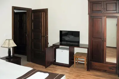 a bedroom with a bed and a tv on a desk at СТАИ ЗА ГОСТИ в КЪЩА КАМЕЛИЯ in Pamporovo