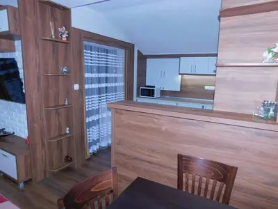 a kitchen with a counter and a table and chairs at Vihren Boutique Apartment in Bansko