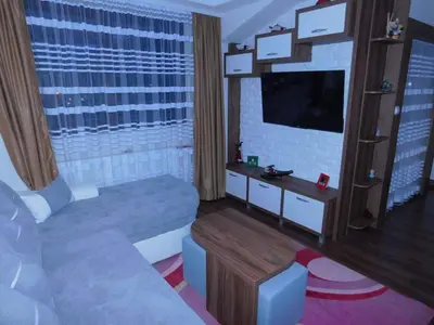 a living room with a couch and a flat screen tv at Vihren Boutique Apartment in Bansko