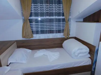 a small bed in a room with a window at Vihren Boutique Apartment in Bansko