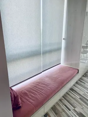 a window seat in a room with a pink cushion at Turquoise and Magenta Apartments in Sofia