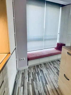 a room with a window with a red couch at Turquoise and Magenta Apartments in Sofia