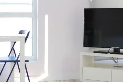 a living room with a tv on a white entertainment center at Turquoise and Magenta Apartments in Sofia