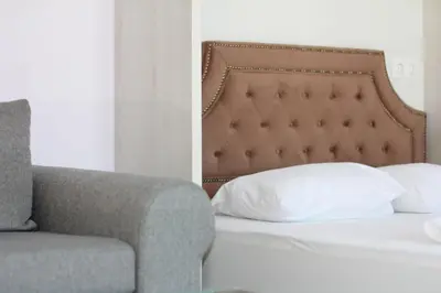 a bedroom with a bed and a couch and a pillow at Turquoise and Magenta Apartments in Sofia