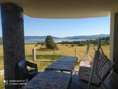 a table and chairs on a porch with a view of a field at VILLA RELAX in Tsigov Chark