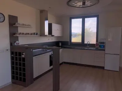 a kitchen with white appliances and a wooden floor at VILLA RELAX in Tsigov Chark