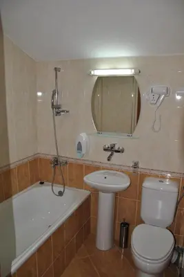 a bathroom with a toilet and a sink and a bath tub at Family Hotel Shoky in Chepelare