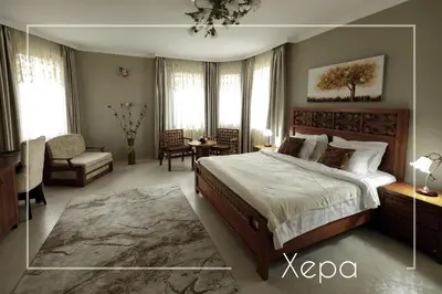 a large bedroom with a large bed and a chair at Boutique & Spa Hotel Heaven in Velingrad