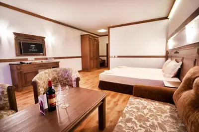 a hotel room with a bed and a table with a bottle of wine at Boutique Complex Trakiets in Zhitnitsa