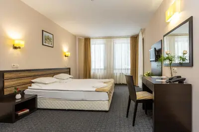 a hotel room with a bed and a desk at Hotel Mursalitsa by HMG - Half board in Pamporovo