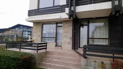 a house with glass windows and stairs on it at Studio L006 in Aspen Golf in Bansko