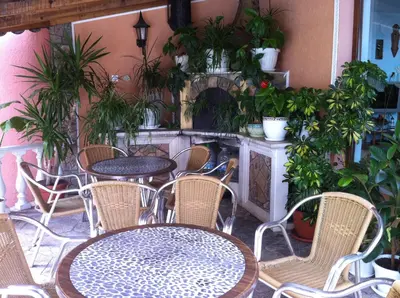 a patio with tables and chairs and potted plants at Vila Kalvachevi in Tsigov Chark