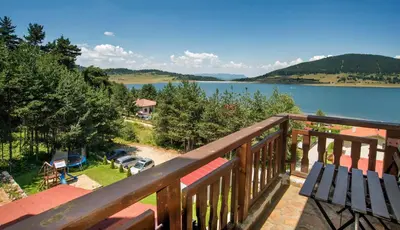 a balcony with a view of a lake at Guest House Slunchev Cviat in Tsigov Chark