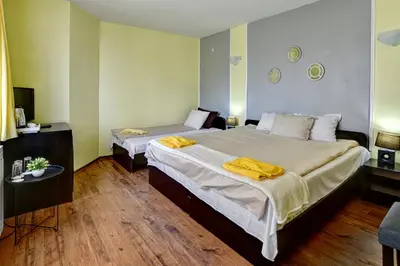 a bedroom with two beds with yellow towels on them at Guest House Slunchev Cviat in Tsigov Chark