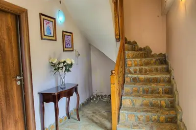 a stairway with a vase of flowers on a table at Guest House Slunchev Cviat in Tsigov Chark