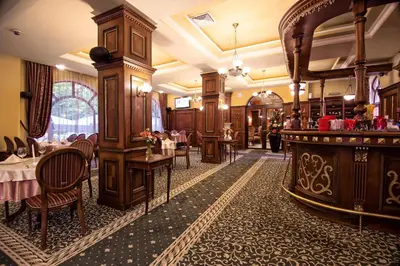 a restaurant with tables and chairs and a bar at Hotel Chinar in Hisarya