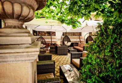 a restaurant with chairs and tables and umbrellas at Hotel Chinar in Hisarya