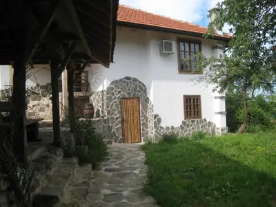 a white house with a wooden door and a yard at Villa Mark in Kraevo