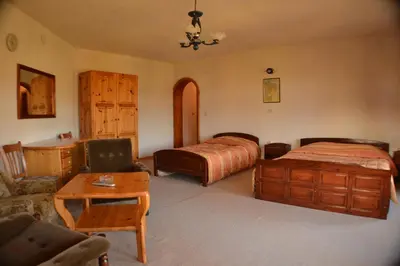 a bedroom with two beds and a couch and a table at Family Hotel Silver in Smolyan