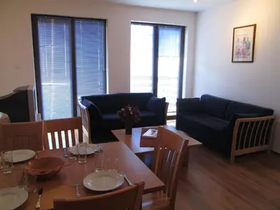 a living room with a table and chairs and a couch at Gramadeto Complex Alexander Services Apartments in Bansko