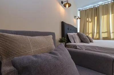 a bedroom with a bed and a couch and a window at ★ Stylish & Cozy Studios in Valentina Heights Boutique Hotel ★ in Bansko