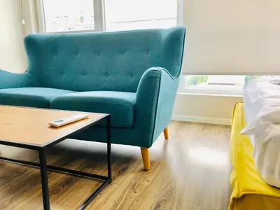a living room with a blue couch and a coffee table at Turquoise and Magenta Apartment in Sofia
