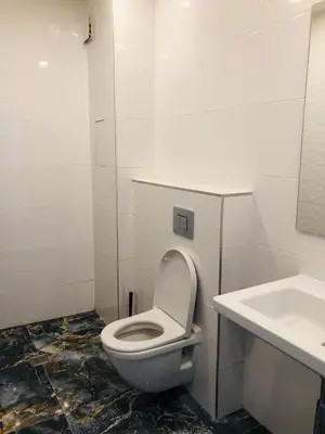 a bathroom with a toilet and a sink at Turquoise and Magenta Apartment in Sofia