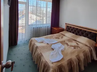 a hotel room with a bed with towels on it at Guest Rooms Grachenovi in Bansko