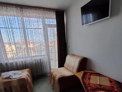 a room with a bed and a chair and a window at Guest Rooms Grachenovi in Bansko