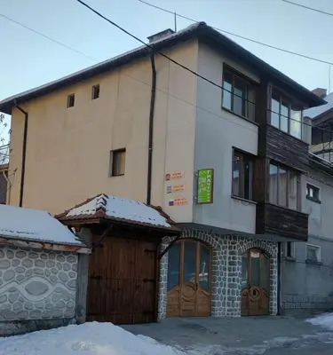a building with snow on the ground in front of it at Guest Rooms Grachenovi in Bansko