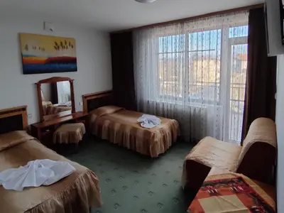 a hotel room with three beds and a mirror at Guest Rooms Grachenovi in Bansko