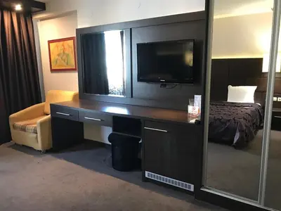 a hotel room with a desk with a television and a bed at Hotel Kardinal in Blagoevgrad