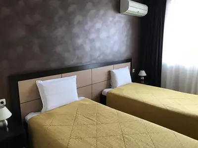 a hotel room with two beds and a window at Hotel Kardinal in Blagoevgrad
