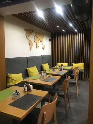 a restaurant with tables and chairs and a map on the wall at Hotel Kardinal in Blagoevgrad