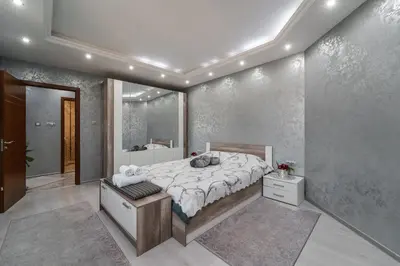 a bedroom with a large bed and a bathroom at City Apartments - a brand new luxury & comfy. in Asenovgrad